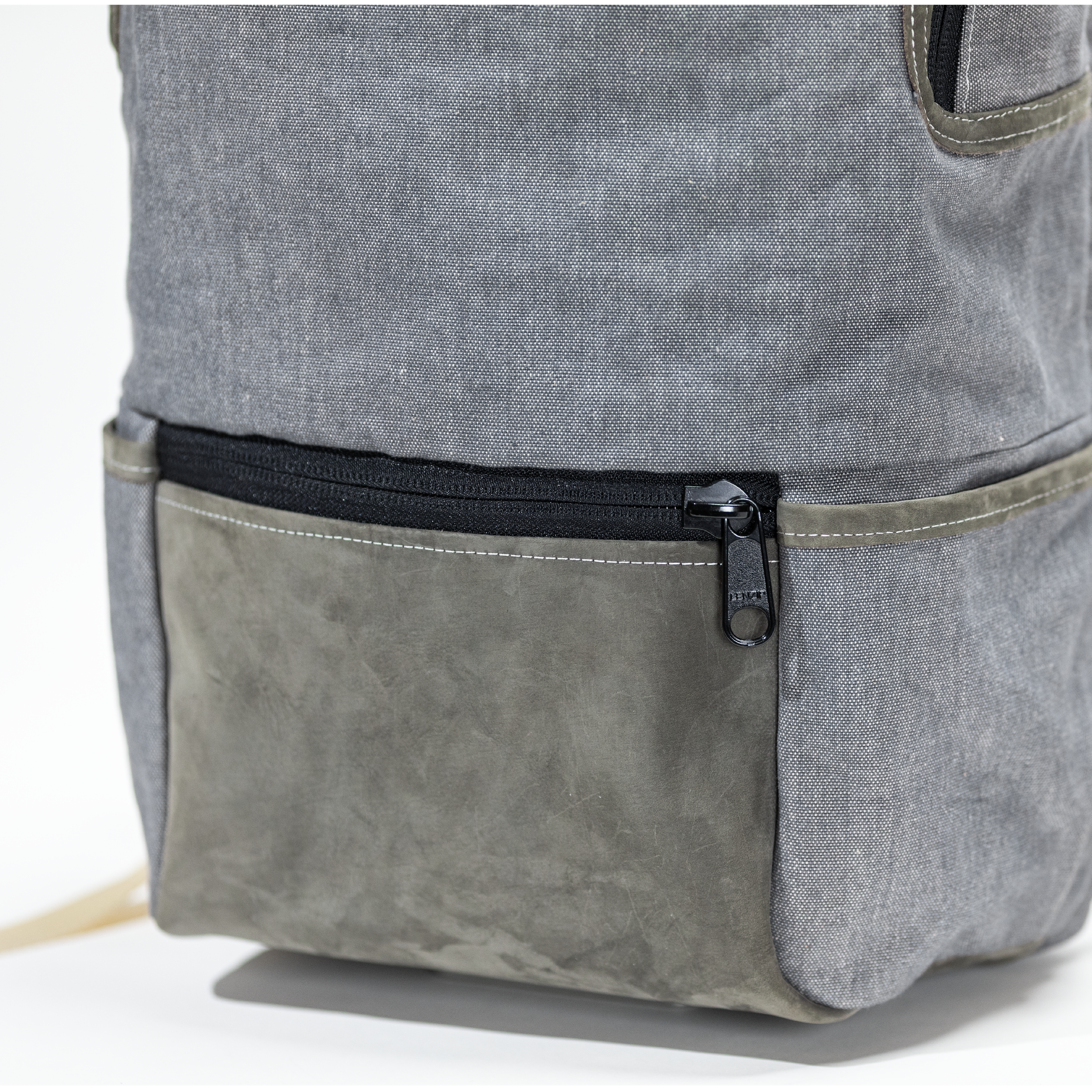 Close-up of the backpack's brass buckles and leather straps — handcrafted details built to last