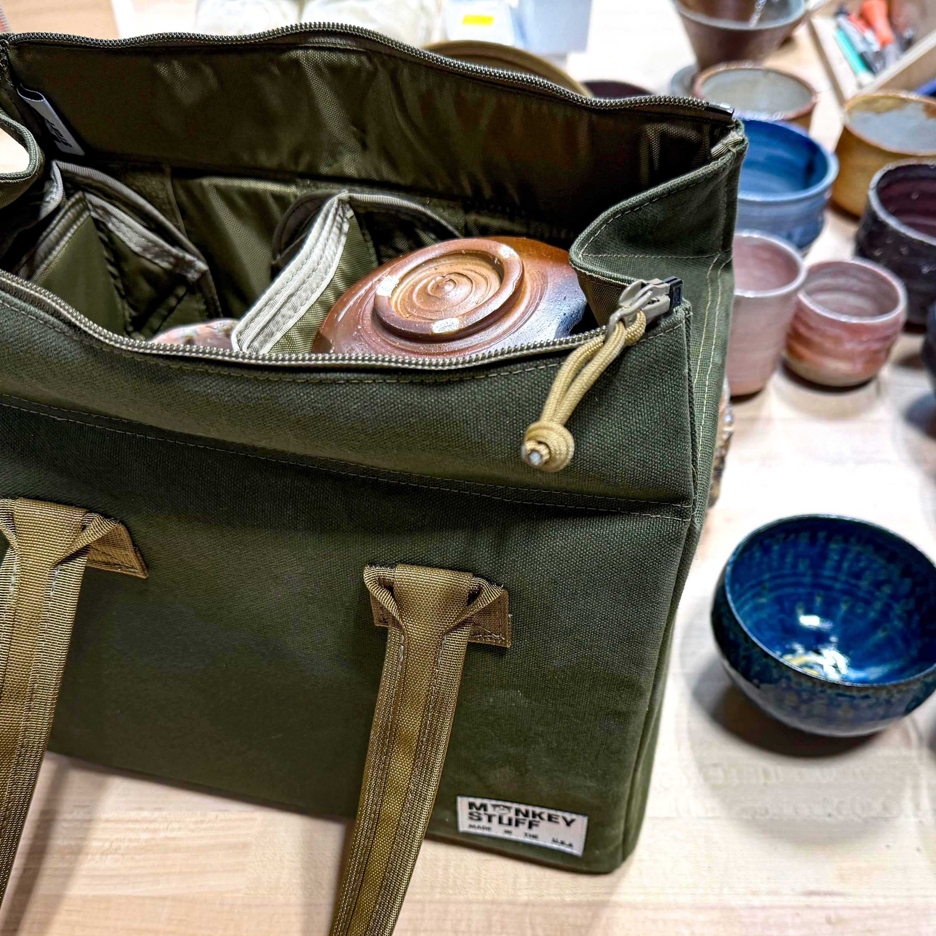 Bowl bag opened showing padded interior with a ceramic bowl safely nestled inside for transport