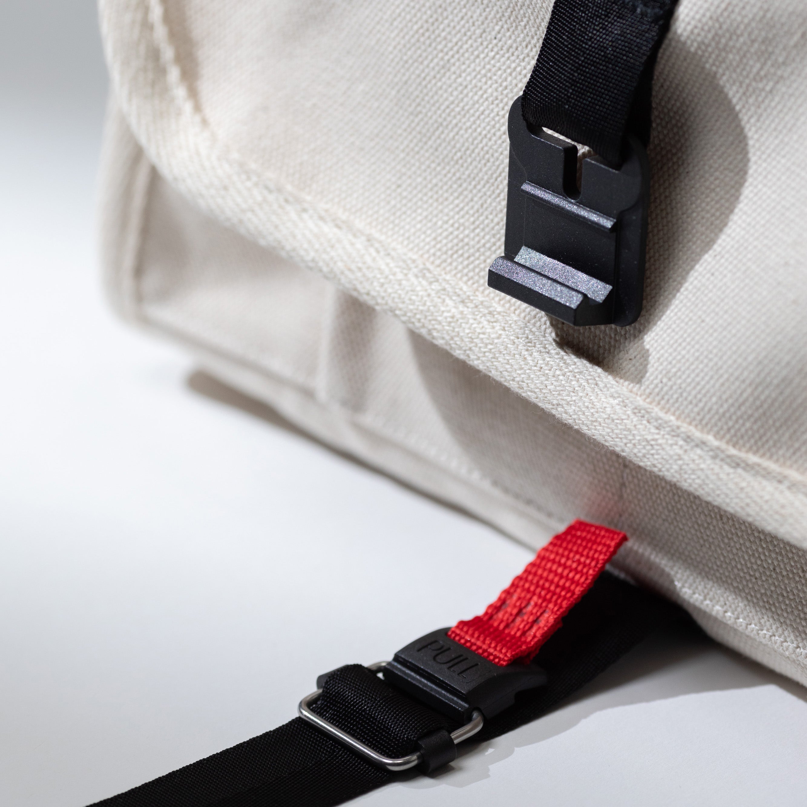 Close-up of the tech pouch's recycled canvas exterior buckle — durable everyday carry