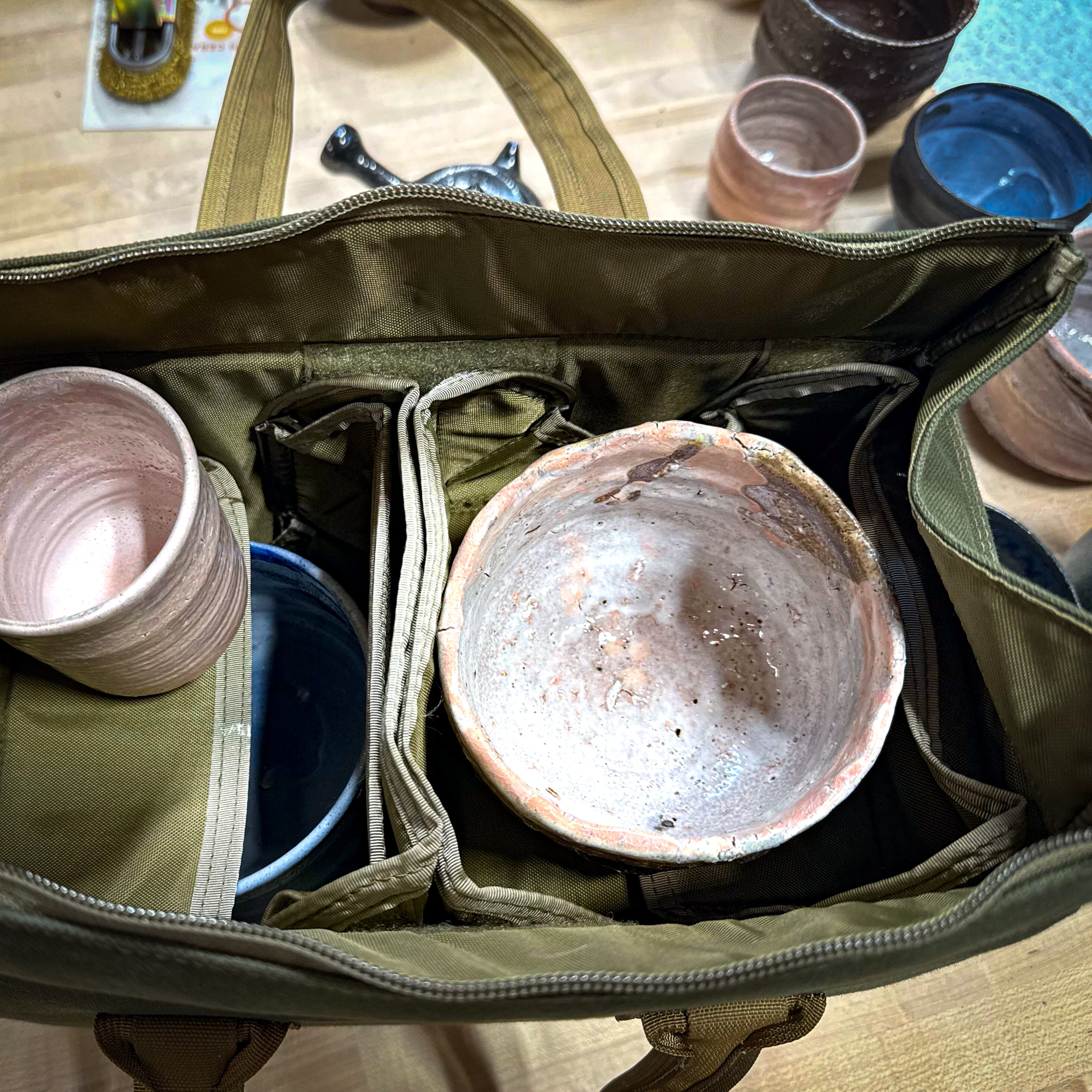 Bowl bag opened showing padded interior with a ceramic bowl safely nestled inside for transport