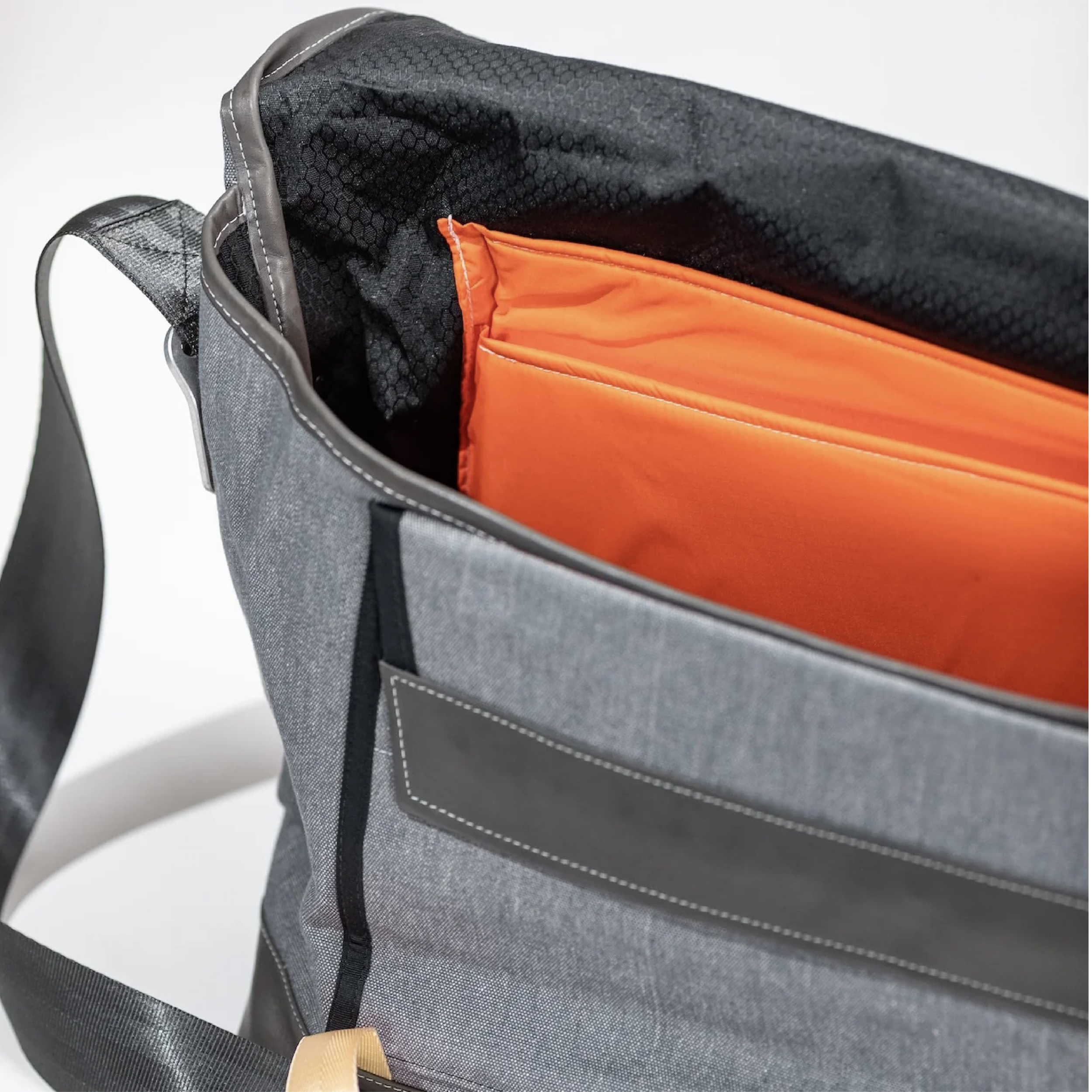 Messenger bag opened to show interior compartments and lining — room for laptop, books, and everyday carry