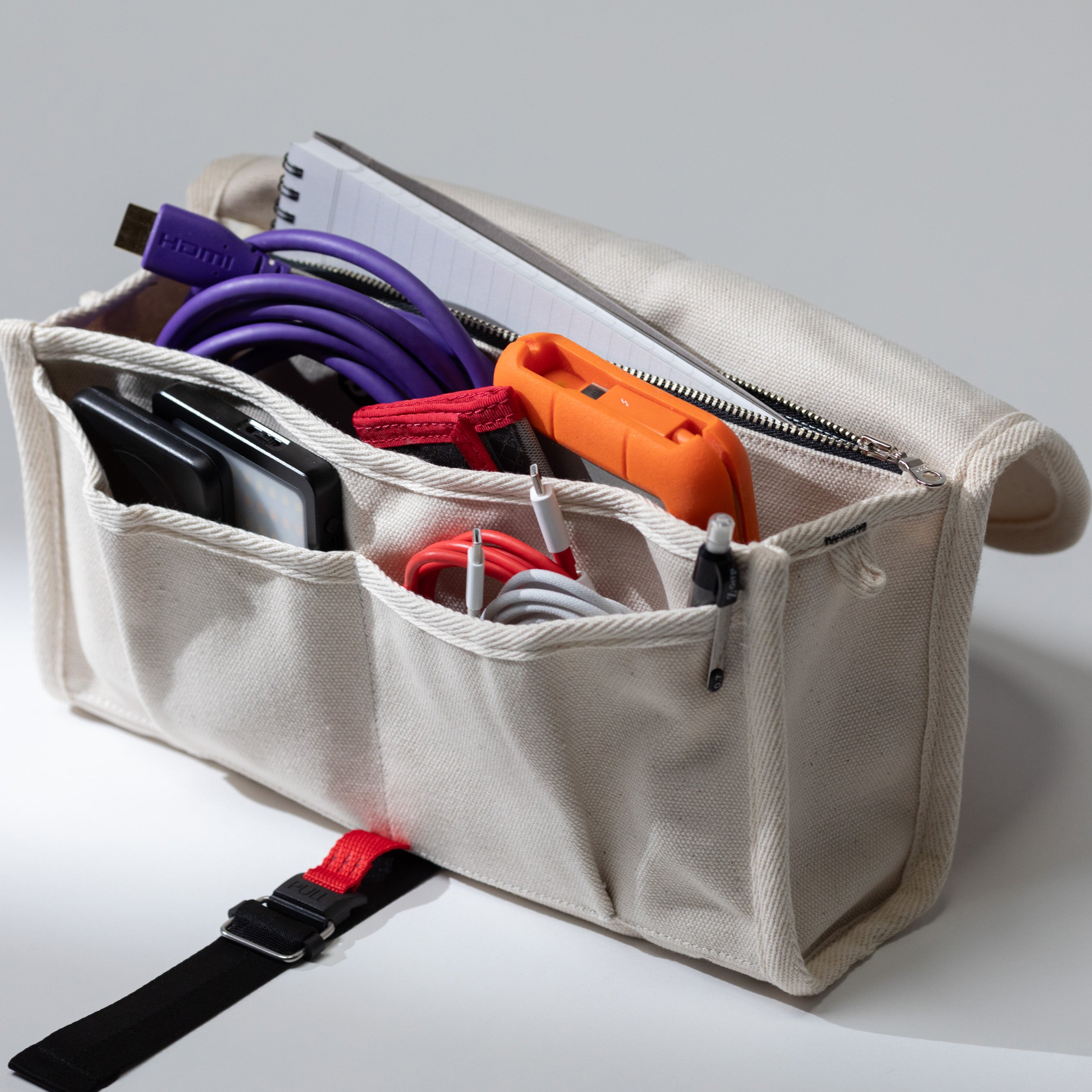 Tech pouch showing interior compartments filled with cables and accessories