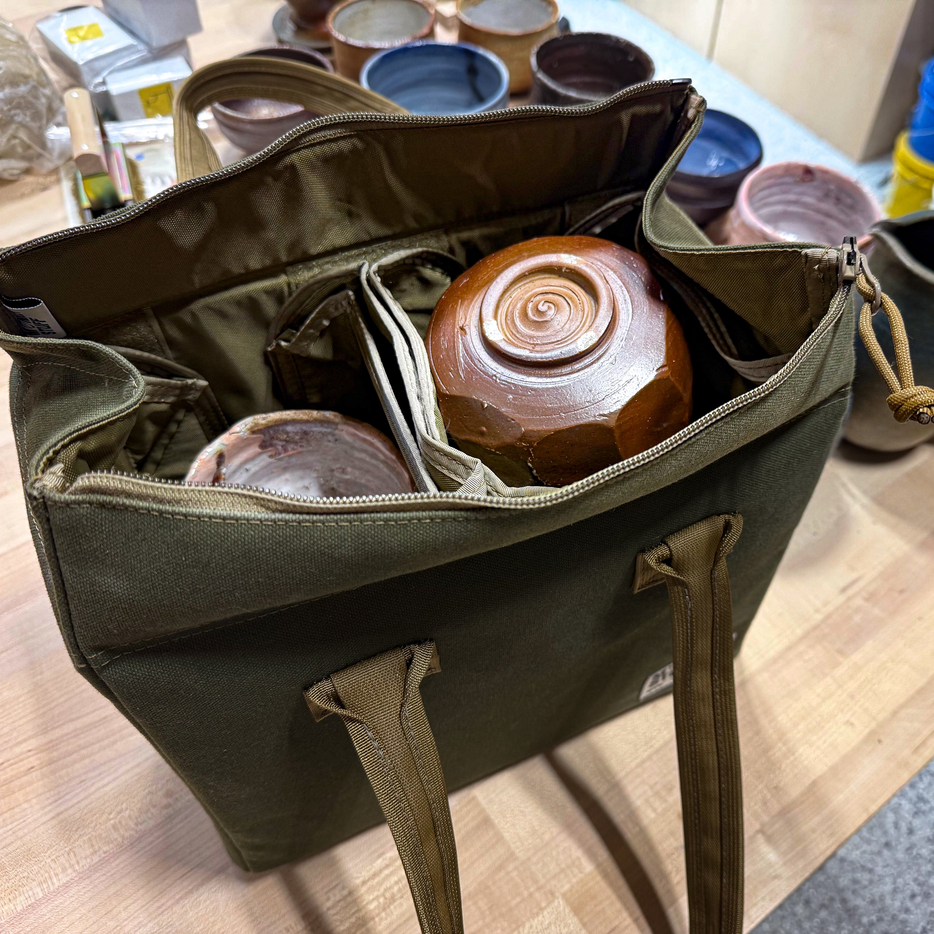Bowl bag opened showing padded interior with a ceramic bowl safely nestled inside for transport